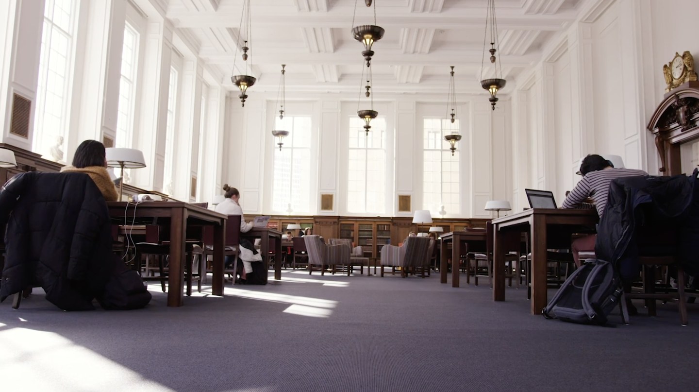 Estudiantes trabajando en una sala de lectura universitaria